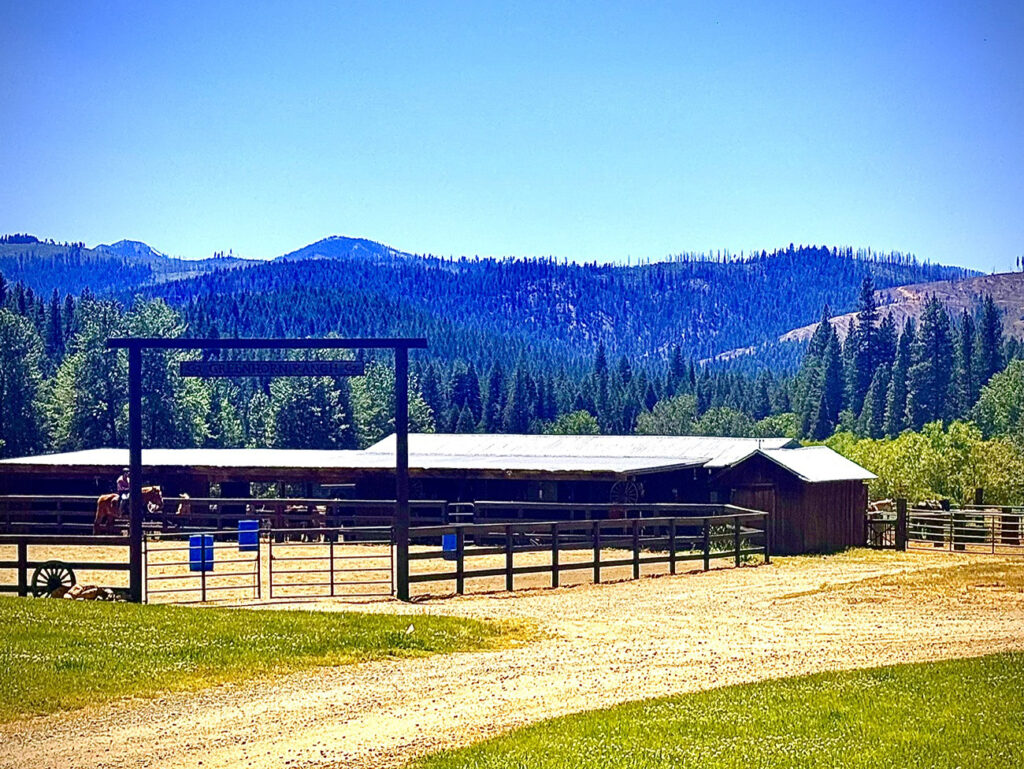View of horse stable with Sierra Mountains in background at Greenhorn Ranch