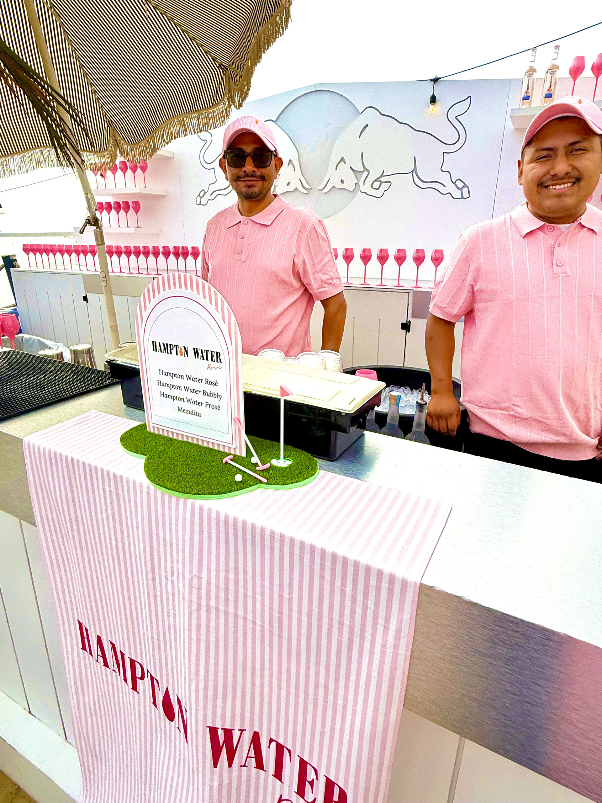 Hampton Water Rose bartenders Two bartenders preparing Hampton Water Rose, Bubbly, Prose and Mezulita's with the Hampton Water logo underneath